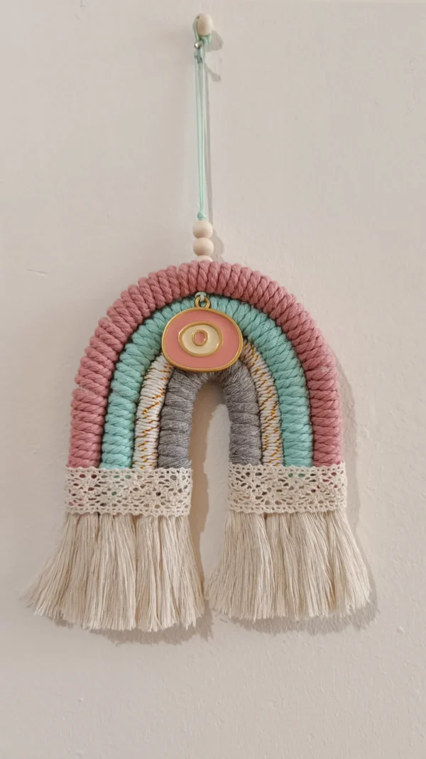Χειροποίητο διακοσμητικό macrame γούρι “ουράνιο τόξο”, διακοσμημένο με μεταλλικό στοιχείο μάτι.