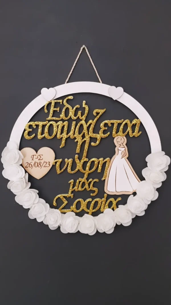 Χειροποίητο ξύλινο στεφάνι “Bride” στολισμένο με λευκά τριαντάφυλλα και χρυσόσκονη.